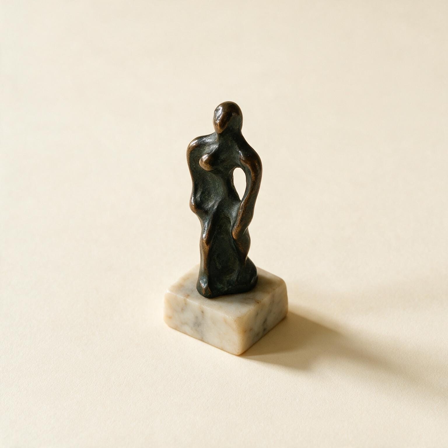 Kleine dunkel patinierte Bronzeskulptur einer abstrakten Figur auf schlichtem Marmorsockel